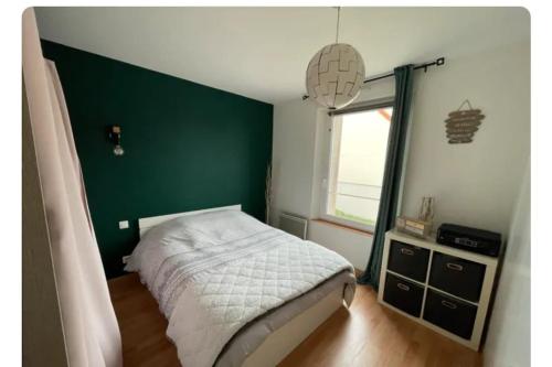 - une chambre dotée d'un lit avec un mur vert dans l'établissement Le Petit Jersey, à Barneville-Carteret