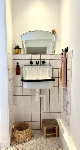 une salle de bain avec un lavabo et un miroir dans l'établissement Le Petit Paradis By Tranquil At Home, à Pornichet