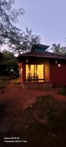 a small house with two chairs in front of it at Niramaya beach view stay in Gokarna