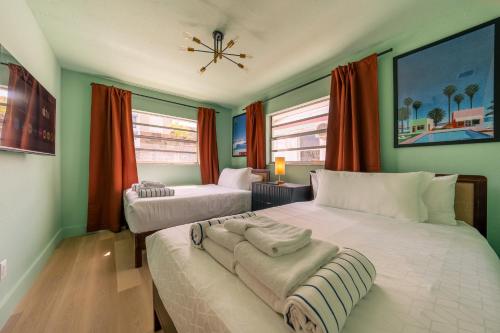 two beds in a room with green walls at Monaco Vacation Rentals in Clearwater Beach