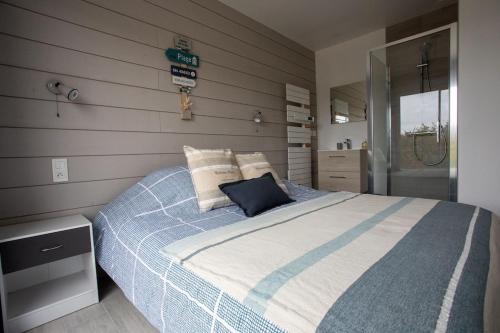 une chambre avec un lit avec une couverture bleue et blanche dans l'établissement Dunes d'Hattainville, à Les Moitiers-dʼAllonne
