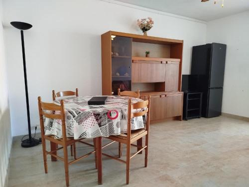 une cuisine avec une table, des chaises et un réfrigérateur dans l'établissement Plage, commerces et animations pour ce T2 avec parking privatif -5AT30, à Saint Cyprien Plage