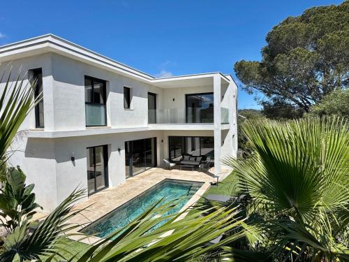 une maison blanche avec une piscine devant dans l'établissement Contemporary Villa with Heated Pool Near Sea, à Saint-Raphaël