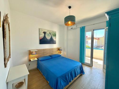 a bedroom with a blue bed and a window at Villa Ranieri-Casa con vista a Campo di mare in Torre San Gennaro