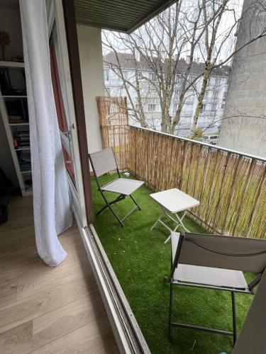 - un balcon avec 2 chaises et 2 tables dans l'établissement Les Tulipiers, à Nantes