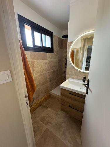 une salle de bain avec un lavabo et un miroir dans l'établissement T2 coloré proche mer terrasse parking, à Six-Fours-les-Plages