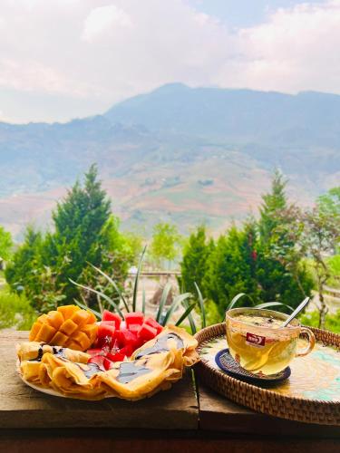 a plate of food and a cup of tea on a table at Táo Tày House in Sa Pa