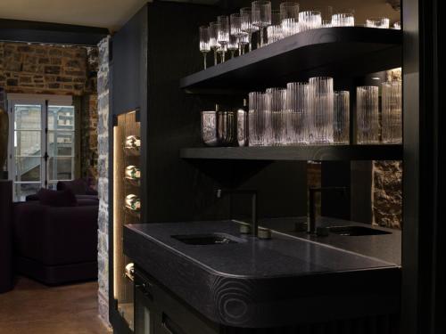 eine Küche mit einer Theke mit Gläsern auf einem Regal in der Unterkunft Hôtel Maison du Fort in Québec