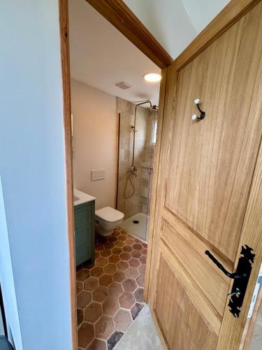 La salle de bains est pourvue de toilettes, d'une douche et d'une porte. dans l'établissement Peaceful Provence - modern countryside tower, à Fourques