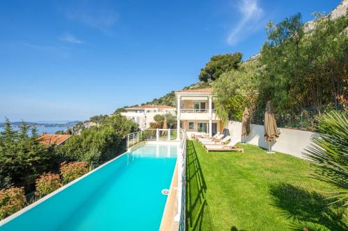 - une vue sur l'extérieur d'une villa avec une piscine dans l'établissement Magnifique Villa vue mer - Piscine - Parkings - DG, à Cap d'Ail