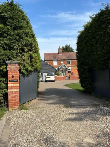 a driveway with a gate and a house with a car at Vineyard Style 2BR with Garden and Parking in Shudy Camps