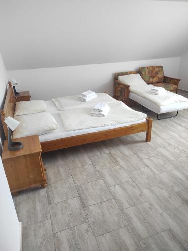 two beds sitting in a room with a floor at Penzion U Jandů in Běhařov