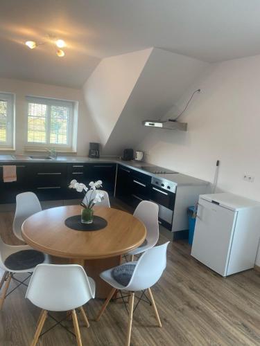 a kitchen with a table and chairs and a refrigerator at Penzion U Jandů in Běhařov