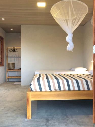 a bedroom with a bed with a striped comforter at Casa Vento Parte Baixa in Luis Correia