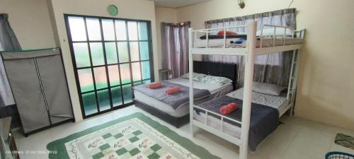 een slaapkamer met twee stapelbedden en een raam bij Din others roomstay in Kuala Terengganu
