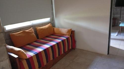 a couch with two pillows sitting in a room at Casa Quinta Roen Gral Rodriguez zona oeste in General Rodríguez
