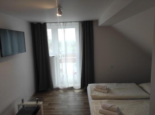 a bedroom with a bed and a large window at Penzion U Jandů in Běhařov