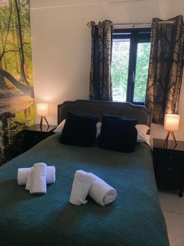 a bedroom with a bed with two towels on it at Hunters Hideaway-Hot Tub-Wiltshire-Groups in Warminster
