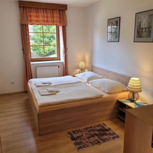 a bedroom with a large bed and a window at Apartment with 2 rooms and kitchen Pension Kubu in Špindlerův Mlýn