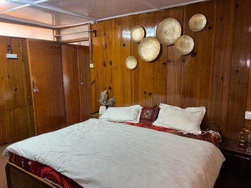 a bedroom with a large bed with wooden walls at nani house the mall in Shimla