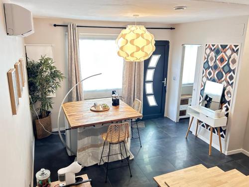 une salle à manger avec une table et des chaises en bois dans l'établissement Chambre luxe avec espace petit déjeuner et travail, à Marmande