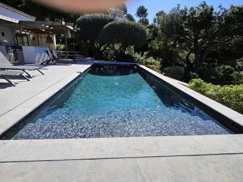 une piscine avec de l'eau bleue dans une cour dans l'établissement Villa de maître avec piscine privée pour 14 personnes, climatisation et animaux admis - FR-1-768-62, aux Issambres