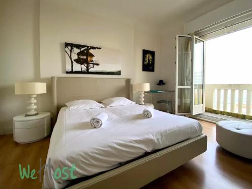 une chambre avec un lit blanc et une grande fenêtre dans l'établissement Régina - Pays Basque - KP - Beautiful loft with ocean view - Parking, à Biarritz