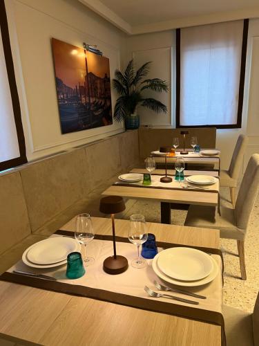 a dining room with two tables with plates and wine glasses at Agriturismo Zapparè Farm Hotel in Trevignano