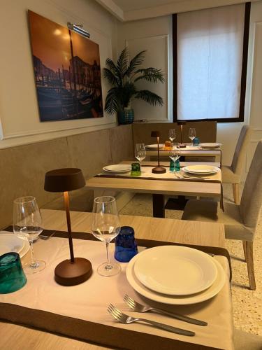 a dining room with a table with plates and wine glasses at Agriturismo Zapparè Farm Hotel in Trevignano