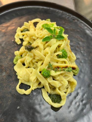 a plate of pasta and broccoli on a table at Agriturismo Zapparè Farm Hotel in Trevignano