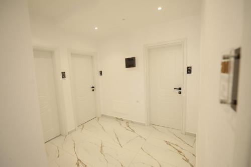 a room with white doors and a marble floor at Hotel Golden Oak in Ksamil