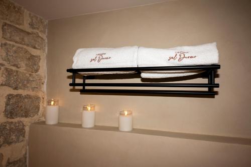 a shelf with towels and candles on a wall at La porta sul Duomo in Barletta
