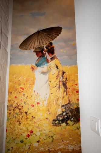 a painting of two women holding an umbrella at La porta sul Duomo in Barletta