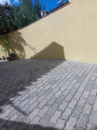 a shadow of a wall on a brick sidewalk at Su Furriadroxiu in San Vito