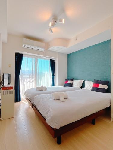 a bedroom with a large bed with a blue wall at La Parfait de 札幌駅前 in Kita-rokujō