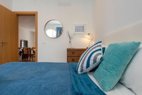 ein Schlafzimmer mit einem blauen Bett mit zwei Kissen in der Unterkunft Lush Botanic Oasis with a Boho Hideaway, Near Beach & Cafés in Lagos