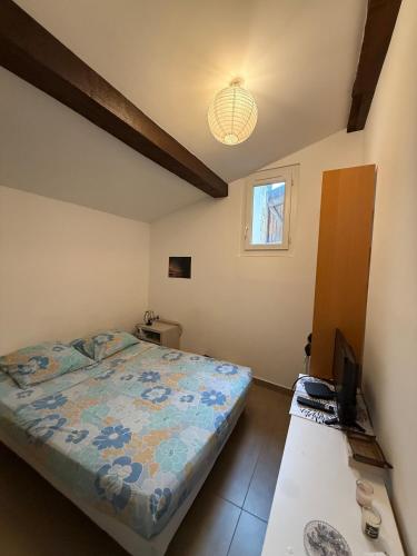 - une chambre avec un lit et une télévision sur une table dans l'établissement Charmant T2 rénovée en centre ville Ajaccio, à Ajaccio