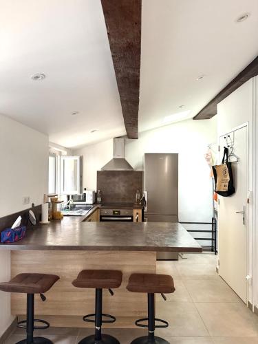 une cuisine avec un grand comptoir et des tabourets. dans l'établissement Charmant T2 rénovée en centre ville Ajaccio, à Ajaccio