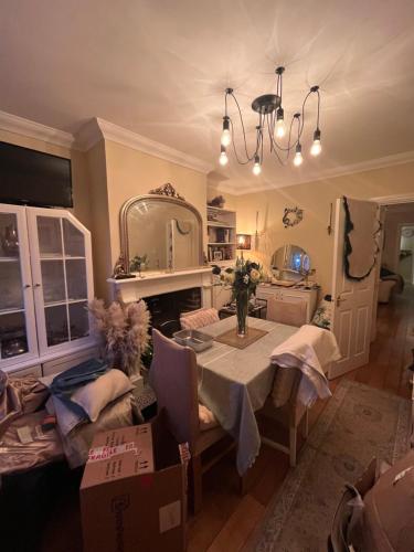 a dining room with a table and a mirror at Cluaine Meala cottage in Isleworth
