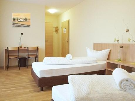 a hotel room with two beds and a television at Campus Bad Kissingen in Bad Kissingen