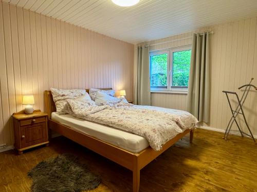 a bedroom with a bed and a window at Meridiamus 2 - Ferienhäuschen in Boddennähe in Ribnitz-Damgarten