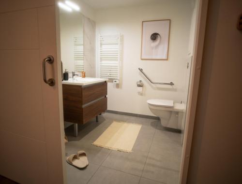 une salle de bain avec un lavabo, des toilettes et un miroir dans l'établissement Résidence CAZAM L'HAY LES ROSES, à Chevilly-Larue