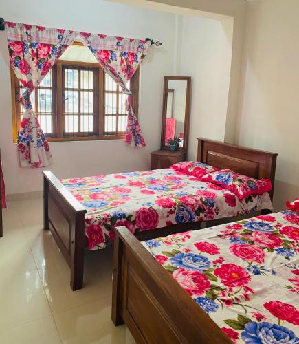 a bedroom with two beds and a window at Pilgrims Rest in Polonnaruwa