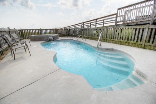 una piscina en un patio con una valla en Salty Banana by Carolina Beach Realty, en Kure Beach