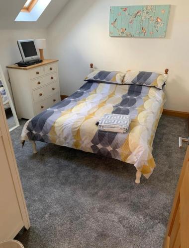 a bedroom with a bed with a laptop on a dresser at Portstewart - holiday let in Portstewart