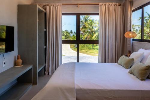 une chambre avec un grand lit et une grande fenêtre dans l'établissement Casa Mar Kaak - Conforto e Privacidade na Praia do Marceneiro - Com Serviço, à Passo de Camarajibe