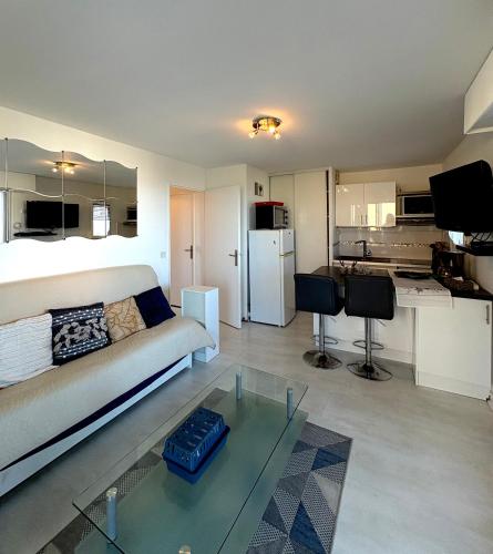 un salon avec un canapé et une table en verre dans l'établissement Superbe vue Appartement 4 à 6 personnes front de mer 6FLOTB79, au Barcarès