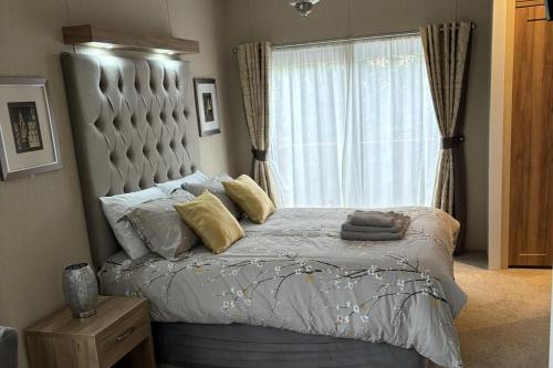 una camera da letto con un letto grande e una finestra di Edinburgh Lodge-Sleeps 6-Pet Friendly-Beach&Views a Prestonpans