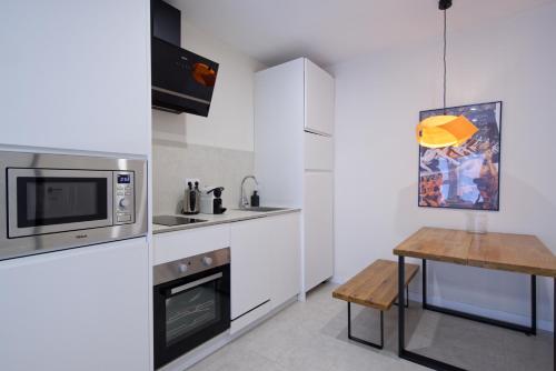 a kitchen with a microwave and a wooden table at Osito Hub - l'Explorador Andrés in Valencia