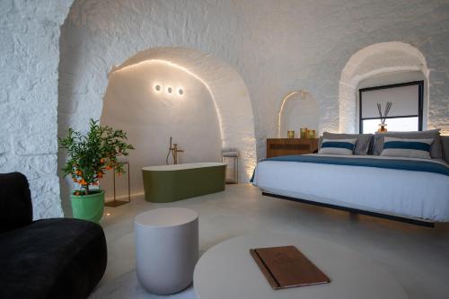 a bedroom with a king sized bed and a couch at Trulli Damari in Locorotondo